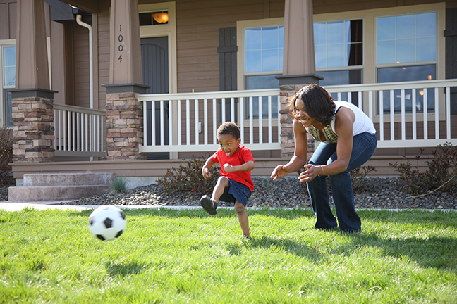 kid playing soccer in front yard